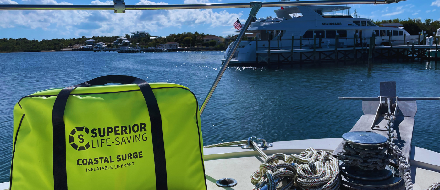 superior life raft in green container with water and large boat in the background.